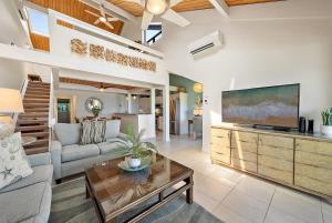 a living room with a couch and a tv at Kahana Village 34 · KHV 34 Direct Ocean Front Views 2BD Kahana C in Kahana