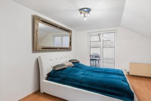 een slaapkamer met een bed met een blauwe deken bij Black Dragon Haven Villa with Pool Sauna Jacuzzi BBQ & Parking for 8 Cars in Praag