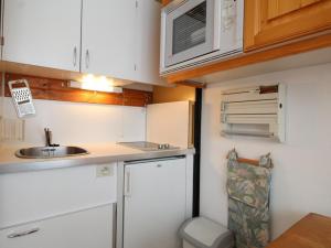 a small kitchen with a sink and a microwave at Studio en front de neige à Flaine, idéal pour skieurs, 4 pers, animaux admis - FR-1-687-58 in Arâches-la-Frasse