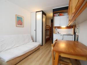 a living room with a white couch and a wooden table at Studio en front de neige à Flaine, idéal pour skieurs, 4 pers, animaux admis - FR-1-687-58 in Arâches-la-Frasse