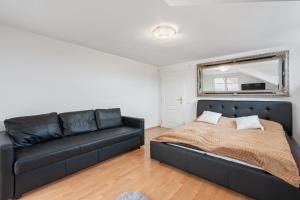 een slaapkamer met een zwart bed en een bank bij Black Dragon Haven Villa with Pool Sauna Jacuzzi BBQ & Parking for 8 Cars in Praag