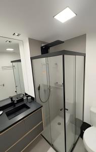 a bathroom with a glass shower and a sink at 602 - Estúdio elegante com piscina e academia in Sao Paulo