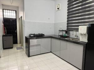 a kitchen with a sink and a counter top at Wareesha Homestay, Corner Lot With Netflix in Padang Serai +10 photos