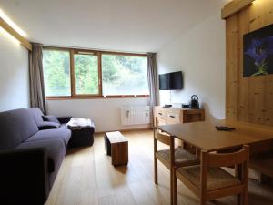 ein Wohnzimmer mit Sofa und Tisch in der Unterkunft Studio rénové 4 pers, Résidence Andromède, Flaine Forêt, à 300m des pistes et 140m des commerces - FR-1-687-26 in Arâches-la-Frasse