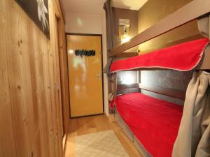ein Schlafzimmer mit einem Etagenbett mit einer roten Decke in der Unterkunft Studio rénové 4 pers, Résidence Andromède, Flaine Forêt, à 300m des pistes et 140m des commerces - FR-1-687-26 in Arâches-la-Frasse