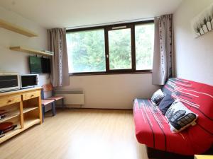 ein Wohnzimmer mit einem roten Sofa vor einem Fenster in der Unterkunft Studio 4 pers, lave-vaisselle, proche pistes et commerces, navette gratuite - FR-1-687-47 in Arâches-la-Frasse