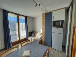 eine kleine Wohnung mit einem Tisch und einem Kühlschrank und einer Couch in der Unterkunft Charmant Studio Cabine avec Coin Montagne pour 5 Pers., Résidence Doris, Proche Pistes et Commerces. - FR-1-687-62 in Arâches-la-Frasse + 4 Fotos