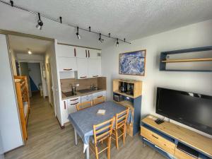 eine Küche und ein Esszimmer mit einem Tisch und einem TV in der Unterkunft Charmant Studio Cabine avec Coin Montagne pour 5 Pers., Résidence Doris, Proche Pistes et Commerces. - FR-1-687-62 in Arâches-la-Frasse