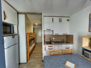 eine kleine Küche mit weißen Schränken und einem Kühlschrank in der Unterkunft Charmant Studio Cabine avec Coin Montagne pour 5 Pers., Résidence Doris, Proche Pistes et Commerces. - FR-1-687-62 in Arâches-la-Frasse