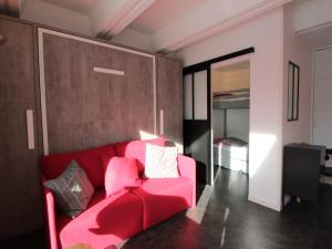 a red couch in a room with a bedroom at Studio rénové pour 4 pers, balcon, au pied des pistes et commerces - FR-1-687-111 in Arâches-la-Frasse +8 photos