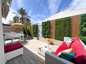 un patio avec un canapé et une table sur une terrasse dans l'établissement Oasis Beach Home II Playa del Inglés, à Playa del Ingles