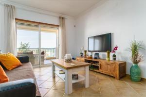 a living room with a couch and a tv and a table at Bright 3-BR in Guia with Shared Pool by Lisbeyond in Guia