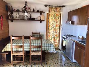 a kitchen with a table and chairs in a kitchen at Appartamento Dolomiti con parcheggio privato coperto in Folgarida +6 photos