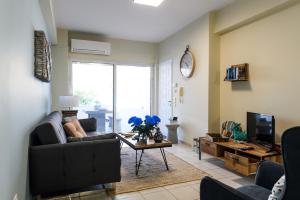 ein Wohnzimmer mit einem Sofa und einem Tisch mit einem TV in der Unterkunft Seaside House In Agios Vasilios in Áyios Vasílios