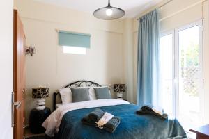 ein Schlafzimmer mit einem Bett mit blauen Laken und einem Fenster in der Unterkunft Seaside House In Agios Vasilios in Áyios Vasílios