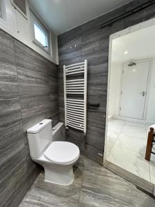 ein Badezimmer mit weißer Toilette und Dusche in der Unterkunft Park House Goodmayes, Ilford London in Goodmayes
