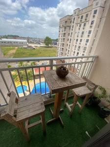 アナニンデウアにあるApt with full club - Rent for seasons!の建物のあるバルコニーに置かれた木製のテーブルとベンチ