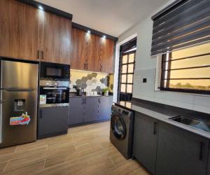 a large kitchen with a washer and dryer in it at Kisaasi Luxury Apartment in Kampala +3 photos