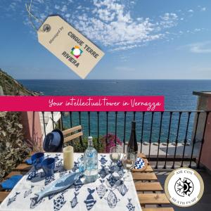 een tafel met een fles wijn en een bordje met de tekst 'uw wildledged flower' bij Refilea Sea View Tower Villa in Vernazza