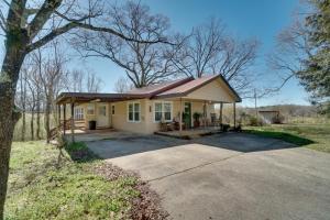 a small yellow house with a tree and a driveway at Wine Country Retreat with Fire Pit and Sunroom! in Dahlonega