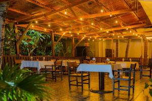 Nosy KombaにあるHôtel de rêve Nosy Kombaの白いテーブルと椅子、照明が備わるレストラン