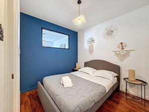a bedroom with a blue wall and a bed at Cosy F2 Royat Thermes in Royat