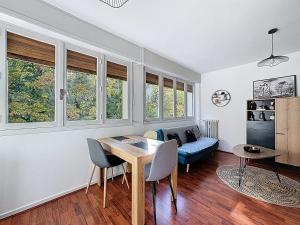 a living room with a table and a couch at Cosy F2 Royat Thermes in Royat