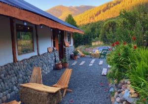 a building with two benches sitting outside of it at Adobe Ecohostel in Villa Meliquina