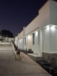 曼齐尼Mbuya Express Inn的一座晚上在户外设有一排长椅的建筑 更多4张照片