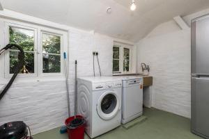 a laundry room with a washing machine in a kitchen at Large family home based at Westerlands Farm in Graffham