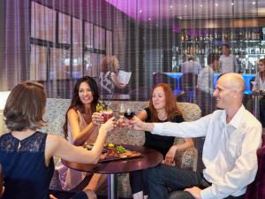 een groep mensen die rond een tafel zitten met een glas wijn bij Mercure Nantes Centre Grand Hotel in Nantes