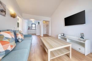 een woonkamer met een blauwe bank en een tafel bij Casa Ondina in Puerto del Carmen