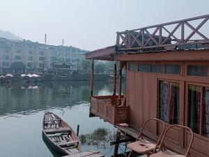 a small house and a boat on the water at Holiday Home in Srinagar
