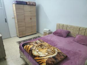 a bedroom with a bed with a tiger blanket on it at Mechi House in Djerba