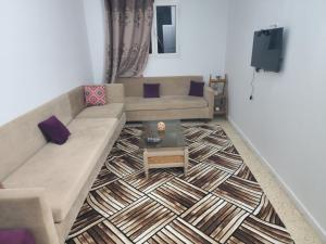 a living room with a couch and a table at Mechi House in Djerba
