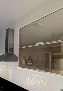 espejo grande en la pared del baño en Recanto da Restinga Guriri House, en São Mateus