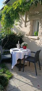 a table and two chairs on a patio with a table and a table at Chez Caroline Chambre d'Hôtes in Plouër-sur-Rance +3 photos