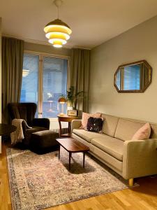 un soggiorno con un divano e un tavolo di Luotsi 1911 Suite a Helsinki