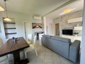 een woonkamer met een blauwe bank en een tafel bij Forato Holiday Appartament in Marina di Pietrasanta