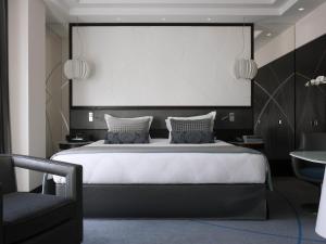 贝鲁特贝鲁特索菲特加布里埃尔酒店的卧室里有一张大床，床上方有一块白板