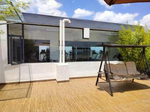a porch with glass walls and a swing at 2 Bed Apartment with En Suite at Menelik Road in Nairobi