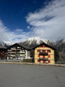 a building with snow covered mountains in the background at Apartaments Eischoll in Arni Alp