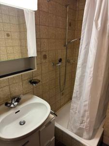 a bathroom with a sink and a shower with a shower curtain at Apartaments Eischoll in Arni Alp