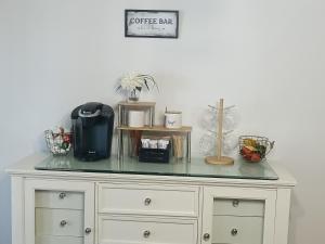 a white dresser with a glass counter top at Zen Gem Near Downtown Detroit and Grosse Pointe in Detroit +2 photos