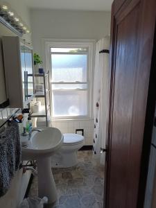 a bathroom with a sink and a toilet and a window at Zen Gem Near Downtown Detroit and Grosse Pointe in Detroit