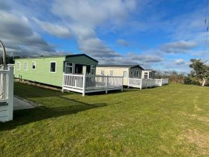 een rij stacaravans op een gazon bij 6 Berth, Pet friendly caravan with Decking - Great Yarmouth in Great Yarmouth