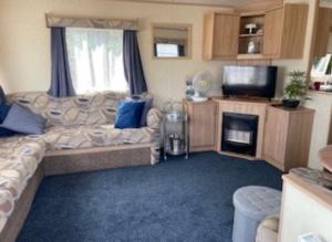 een woonkamer met een bank en een televisie bij 6 Berth, Pet friendly caravan with Decking - Great Yarmouth in Great Yarmouth +9 foto's