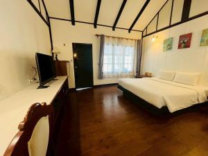 a bedroom with a bed and a television in it at River View House in Ko Chang