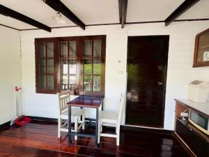 a dining room with a table and chairs and a window at River View House in Ko Chang