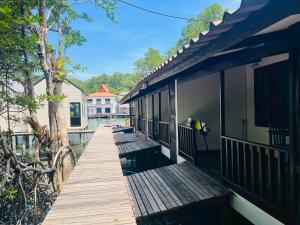 a wooden walkway leading to a house on the water at River View House in Ko Chang